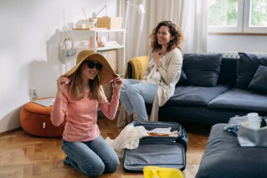 mother and daughter feels excited while packing bags for summer vacation
