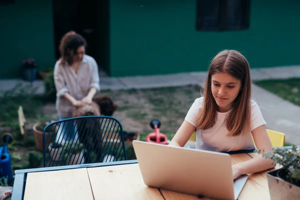 Teenager Girl Using Laptop Computer Outdoor Backyard Her Mother Background — Stockfoto