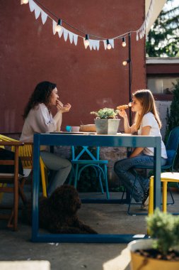 family feeling relaxed having breakfast in home backyard.