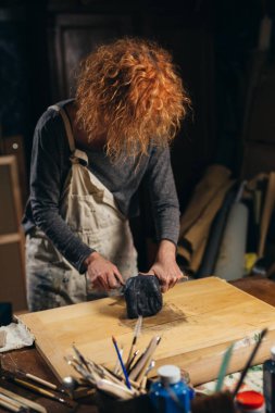 Beyaz kadın çömlek yapmak için kil hazırlıyor.