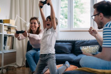 Anne oğluyla evde video oyunu oynuyor.
