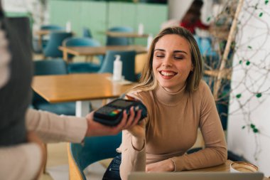 gülümseyen beyaz kadın restoranda kartla oynuyordu.