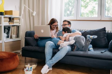 Aile kucaklaşması ve gülümseme oturma odasında kanepede oturur.