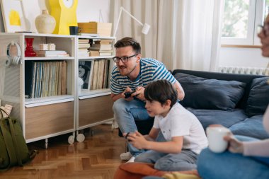 baba ve oğul evde video oyunu oynuyorlar..