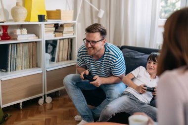 baba ve oğul evde video oyunu oynuyorlar..