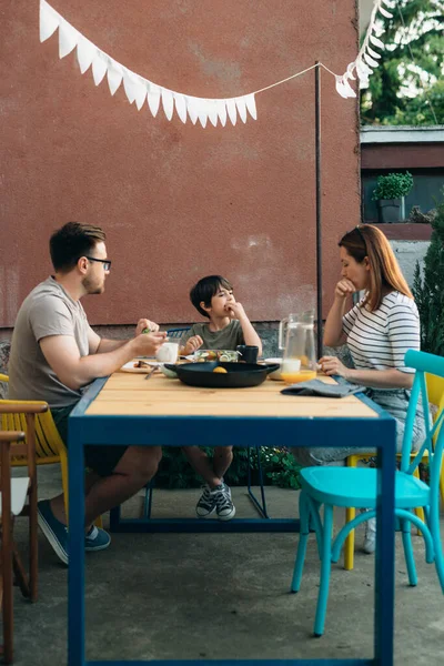 happy caucasian family having lunch together in home backyard