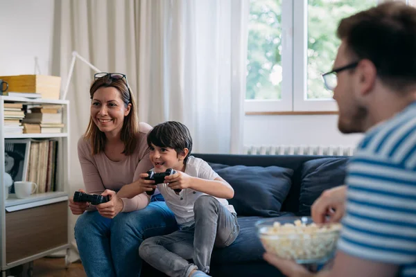 Anne ve oğlu evde video oyunu oynuyorlar.