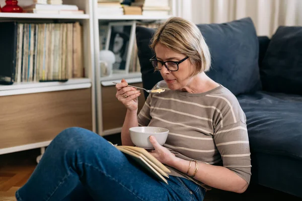 女人在家里放松 读书和吃早餐 — 图库照片