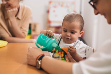 Anaokulunda tatlı bir erkek bebek kahvaltısı.