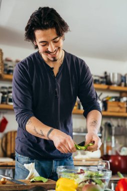 man preparing avocado salad in his kitchen