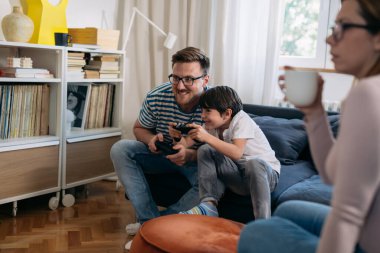 baba ve oğul evde video oyunu oynuyorlar.