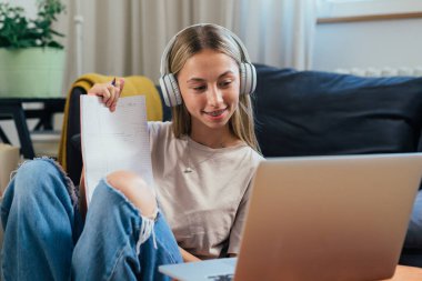 teenager girl having video call with her classmates from her home.