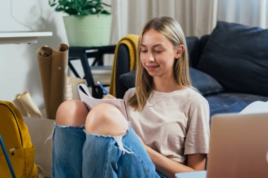 young teenager girl doing her homework in her room