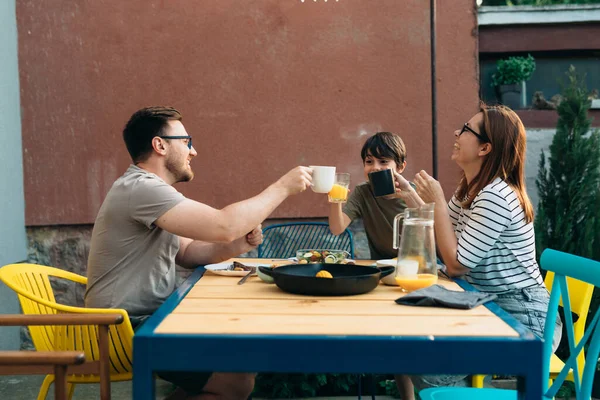 caucasian happy family eats together in backyard