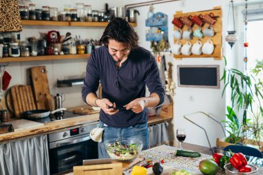 Yemek blogcusu mutfağında salata fotoğrafı çekiyor.