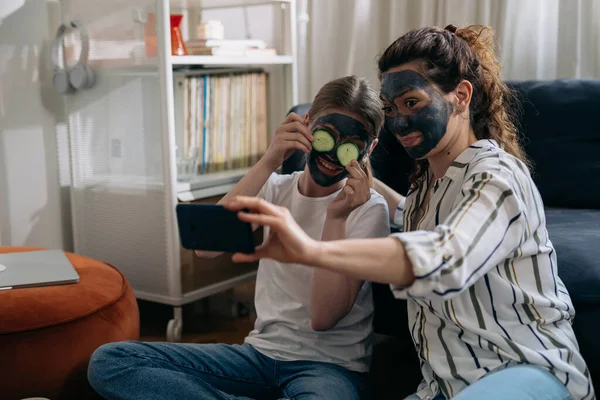 Mother Daughter Taking Selfie Smartphone Cosmetic Face Mask Applied Faces —  Fotos de Stock