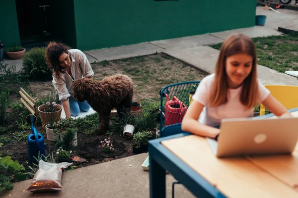Mother Gardening Plants Backyard Daughter Using Laptop — Stockfoto