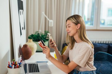 teenager using smartphone for online shopping from her home