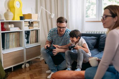 family of three playing video games in living room