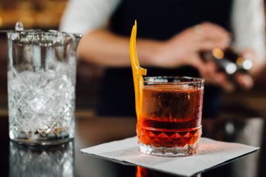 close up of cocktail on bar counter. barman in blurred background