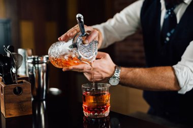 close up of barman pouring drink in glass