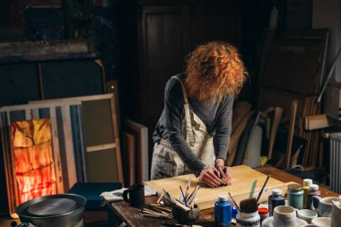 Kadın atölyesinde çömlek yapıyor.