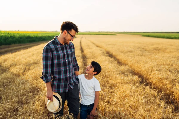 father and son walking through wheat field