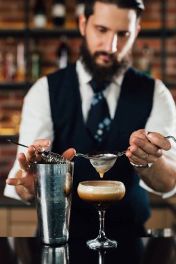 close up of barman preparing espresso martini cocktail