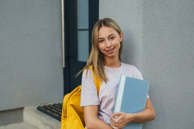 portrait of female caucasian student in front of house