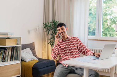 Adam cep telefonundan konuşuyor. Ofisinde oturuyor.