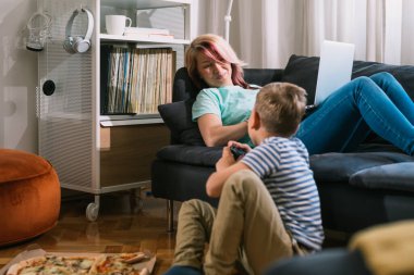 Anne ve oğul evde birlikte vakit geçiriyorlar.