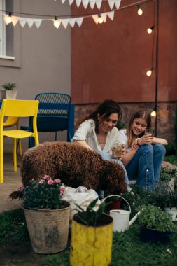 Anne ve kızı evlerinin arka bahçesinde birlikte vakit geçiriyorlar.