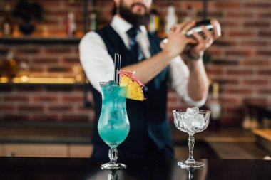 Barmen barda kokteyl hazırlıyor.