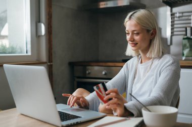 Kadın evinden online alışveriş yapıyor.