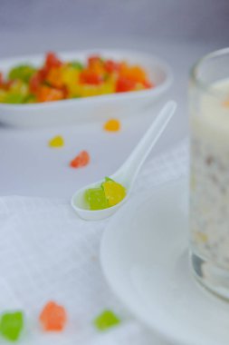 Masanın üzerinde renkli mango meyveleri, tutku meyveleri ve diğer meyveler yatıyor..