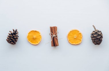 Çam kozalakları, tarçın çubukları, beyaz ahşap arka planda kuru portakal dilimleri gibi doğal dekorasyonlarla tatil yatıyordu. Sıfır Noel konsepti. Plastiksiz tatil. Sürdürülebilir yaşam tarzı.