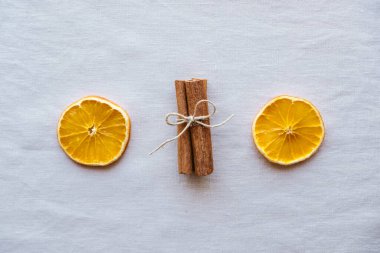 Tarçın çubukları ve tarafsız arka planda kuru portakal dilimleri gibi doğal dekorasyonlarla tatil yatıyordu. Sıfır Noel konsepti. Plastiksiz tatil. Sürdürülebilir yaşam tarzı.