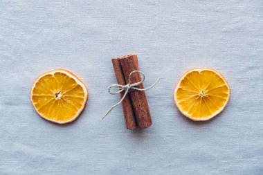 Tarçın çubukları ve tarafsız arka planda kuru portakal dilimleri gibi doğal dekorasyonlarla tatil yatıyordu. Sıfır Noel konsepti. Plastiksiz tatil. Sürdürülebilir yaşam tarzı.