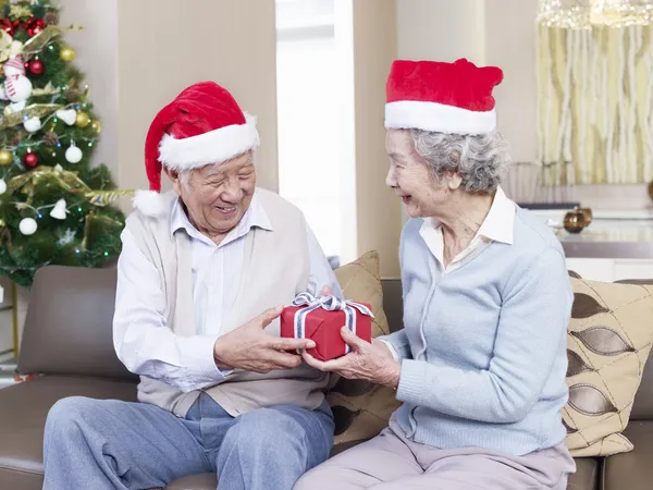 Senior Couple exchanging Christmas gifts — Stock Photo, Image