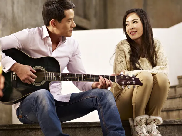 Young lovers playing guitar and singing — Stock Photo, Image
