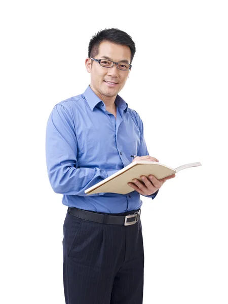 Азиатский мужчина с ручкой и блокнотом — стоковое фото