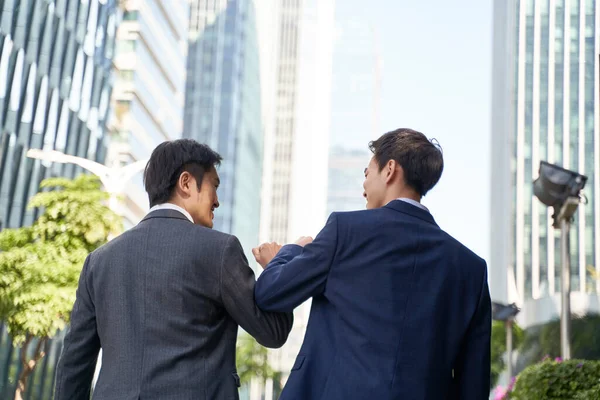 在现代城市的大街上 两个亚洲商人在庆祝成功的时候碰碰手肘 — 图库照片
