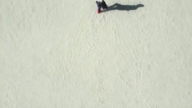 Qinghai, Çin 'de Chaka tuz gölünün suyunda yürüyen Asyalı bir kadının insansız hava aracı görüntüsü.