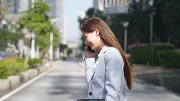 Νεαρή Ασιάτισσα Επιχειρηματίας Μιλάει Στο Τηλέφωνο Ενώ Περπάτημα Στο Δρόμο — Αρχείο Βίντεο