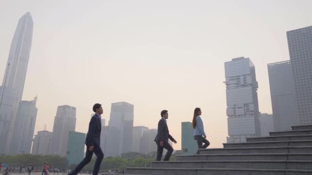 Zespół Trzech Azjatyckich Biznesmenów Wspinających Się Schodach Nowoczesną Panoramą Miasta — Wideo stockowe