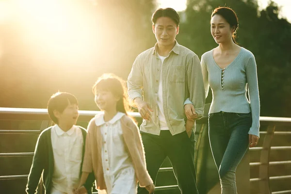 快乐的亚洲家庭 有两个孩子在城市公园的人行天桥上散步 — 图库照片