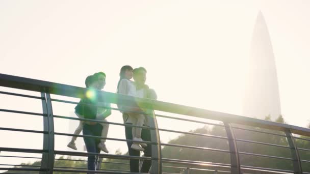 Junge Asiatische Familie Mit Zwei Kindern Steht Auf Brücke Und — Stockvideo