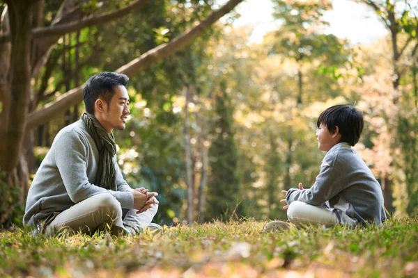 Asiatico Padre Figlio Seduta Erba Avendo Piacevole Conversazione All Aperto — Foto Stock