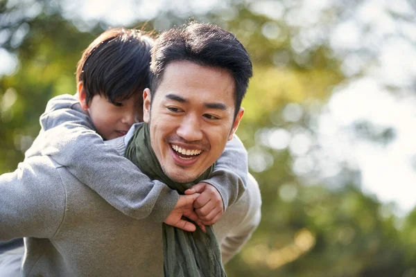亚洲人的父亲背着儿子在公园里玩得很开心 — 图库照片