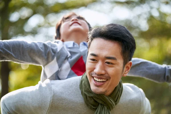 Asian Father Carrying Son Back Having Fun Outdoors Park — Stock Photo, Image